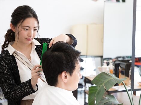 男性をカットするスタッフ